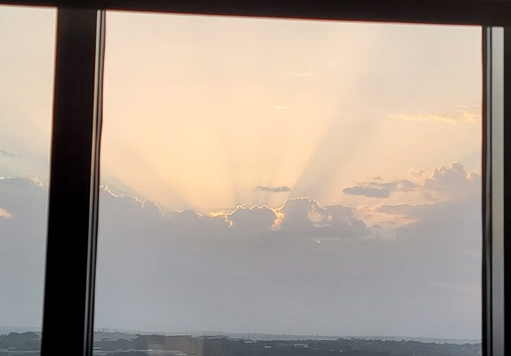 Rays of Sunlight Shine Upwards from Pale Clouds on the Horizon, as seen by my dad form his hospital window